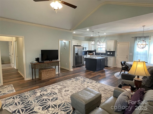 210 Rhyne St, Stanley, NC 28164 - living area featuring a ceiling fan, vaulted ceiling, crown molding, dark wood-style floors, and a chandelier