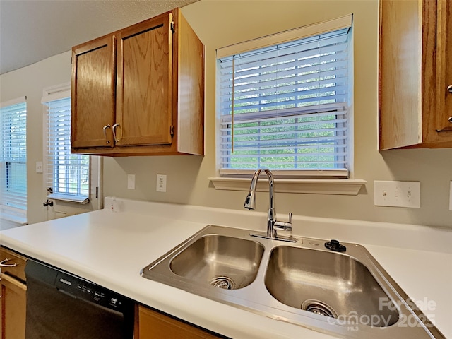 4328 Frank Vance Rd, Charlotte, NC 28216 - kitchen with black dishwasher, a sink, light countertops, and brown cabinetry