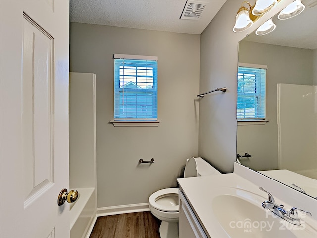 4328 Frank Vance Rd, Charlotte, NC 28216 - full bathroom with wood finished floors, healthy amount of natural light, toilet, vanity, and a textured ceiling