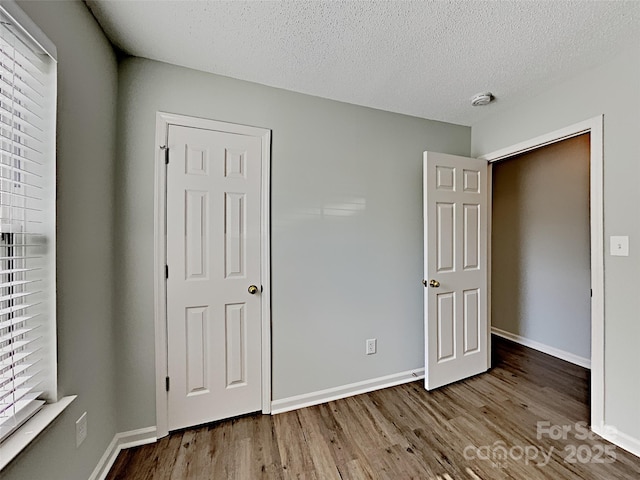 4328 Frank Vance Rd, Charlotte, NC 28216 - unfurnished bedroom with wood finished floors, a textured ceiling, and baseboards