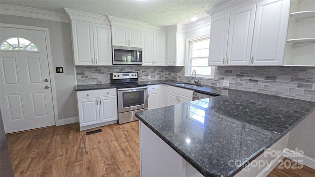 1838 Harmon St, Morganton, NC 28655 - kitchen featuring stainless steel appliances, a sink, open shelves, white cabinetry, and light wood finished floors