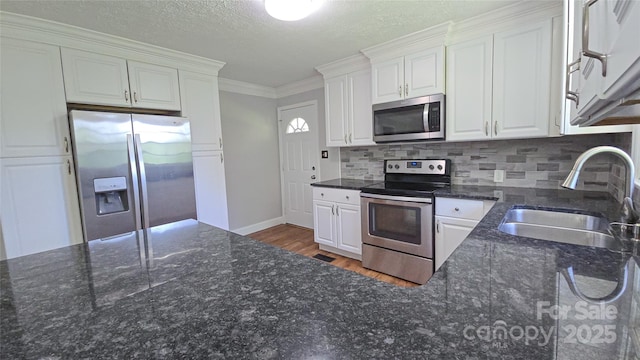 1838 Harmon St, Morganton, NC 28655 - kitchen featuring stainless steel appliances, a sink, white cabinetry, ornamental molding, and a textured ceiling