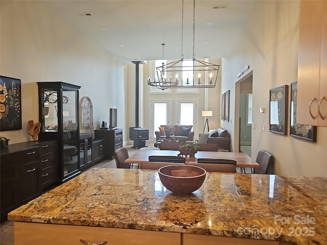 2905 Medlin Rd, Monroe, NC 28112 - kitchen featuring a high ceiling, stone counters, a chandelier, pendant lighting, and french doors