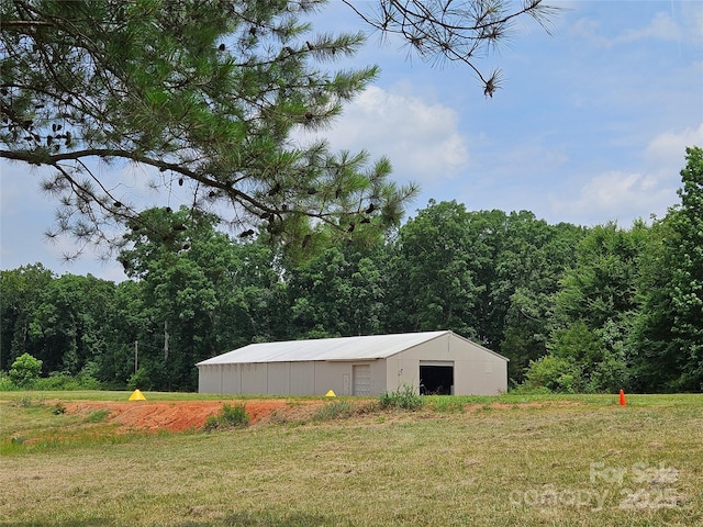 2905 Medlin Rd, Monroe, NC 28112 - view of green lawn featuring a pole building, a forest view, and an outdoor structure