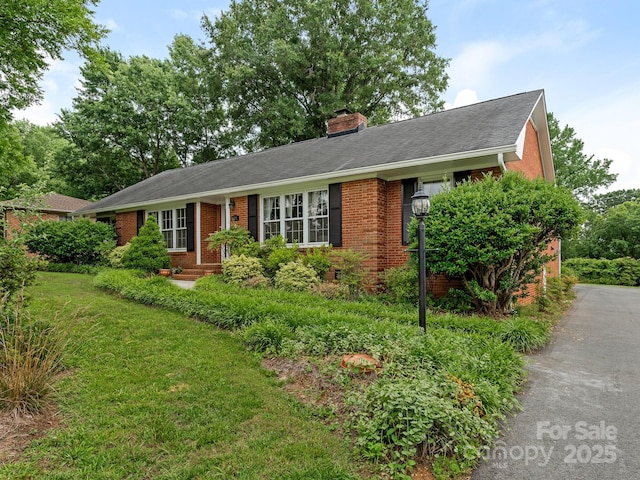 3408 Oak Tree Trl, Matthews, NC 28105 - ranch-style home featuring brick siding, a chimney, and a front yard
