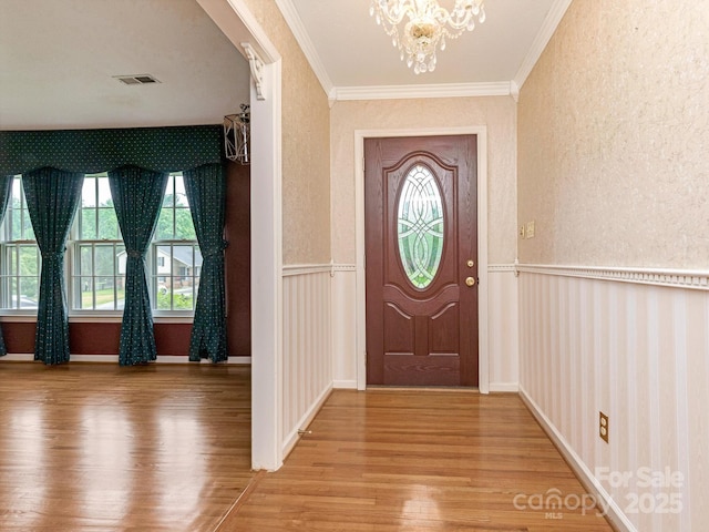 3408 Oak Tree Trl, Matthews, NC 28105 - foyer entrance featuring wood finished floors, a chandelier, crown molding, a wainscoted wall, and a textured wall