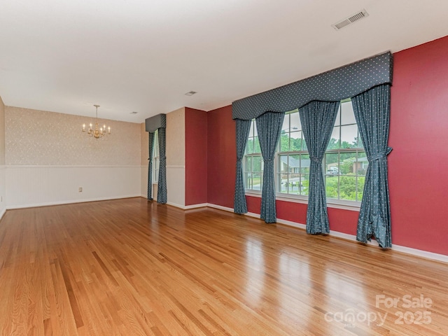 3408 Oak Tree Trl, Matthews, NC 28105 - unfurnished room featuring a chandelier, light wood-style floors, wallpapered walls, and baseboards