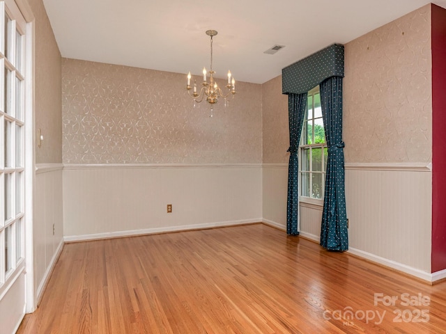 3408 Oak Tree Trl, Matthews, NC 28105 - unfurnished room featuring wainscoting, wood finished floors, wallpapered walls, and a chandelier