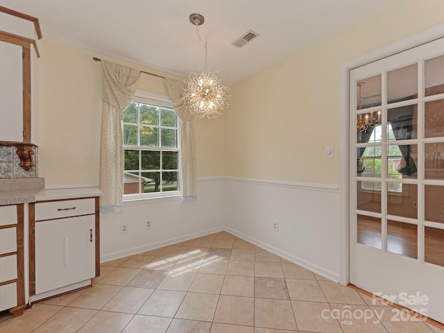 3408 Oak Tree Trl, Matthews, NC 28105 - unfurnished dining area with a chandelier, light tile patterned flooring, and baseboards