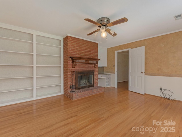 3408 Oak Tree Trl, Matthews, NC 28105 - unfurnished living room with ceiling fan, light wood-style flooring, a brick fireplace, built in features, and crown molding