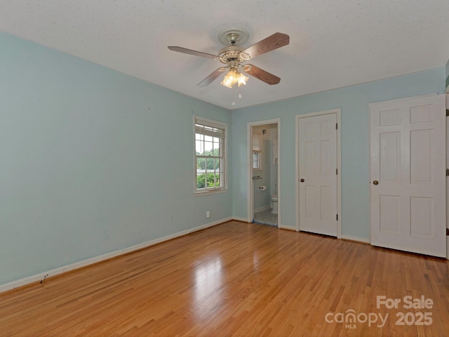 3408 Oak Tree Trl, Matthews, NC 28105 - unfurnished bedroom featuring baseboards, light wood-style flooring, ensuite bath, and ceiling fan