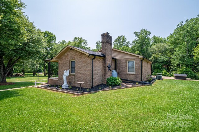 5958 Hoover Elmore Rd, Lincolnton, NC 28092 - view of side of home featuring a chimney, a lawn, brick siding, and central air condition unit