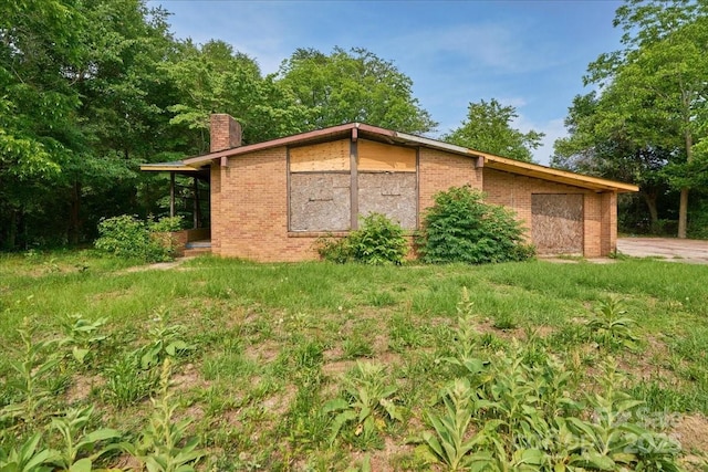 714 Pine St, Hamlet, NC 28345 - view of side of property featuring a chimney and brick siding