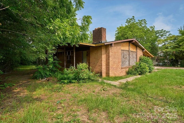 714 Pine St, Hamlet, NC 28345 - view of home's exterior featuring a chimney and brick siding