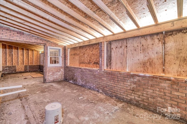 714 Pine St, Hamlet, NC 28345 - miscellaneous room featuring vaulted ceiling and brick wall