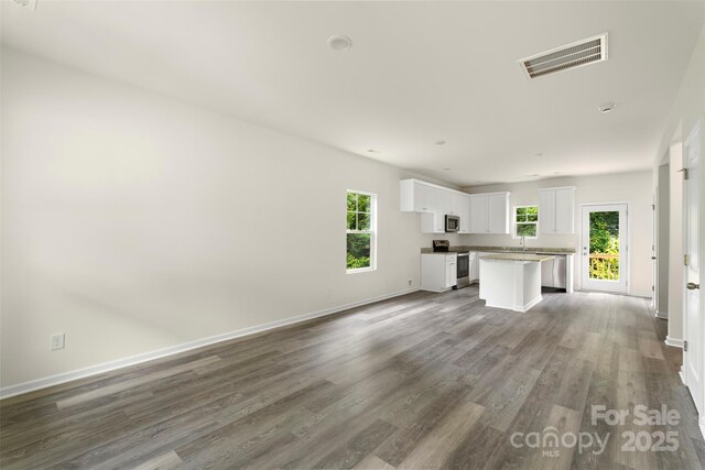 510 3rd St, Salisbury, NC 28144 - unfurnished living room with wood finished floors, baseboards, and a sink