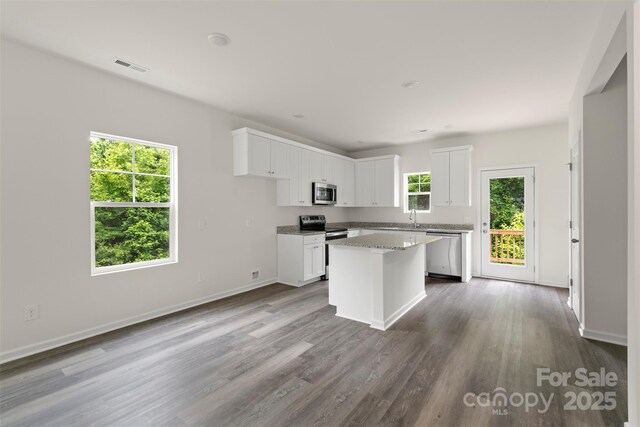 510 3rd St, Salisbury, NC 28144 - kitchen featuring stainless steel appliances, a sink, white cabinets, a center island, and dark wood finished floors