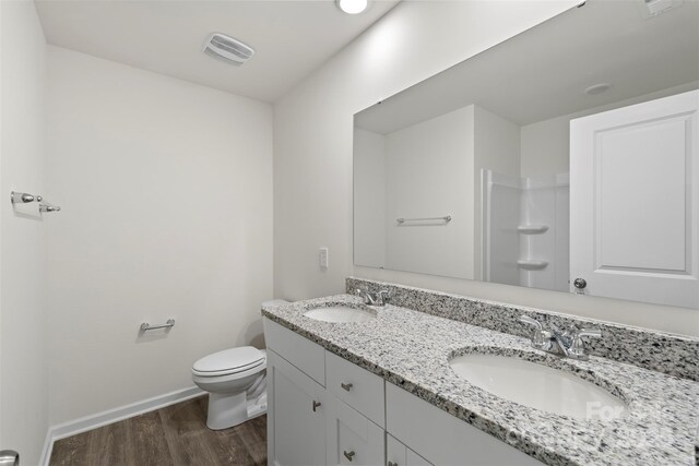 510 3rd St, Salisbury, NC 28144 - full bathroom featuring wood finished floors, double vanity, baseboards, and toilet