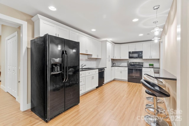 12 Broadmoor Dr, Arden, NC 28704 - kitchen with black appliances, dark countertops, light wood-style floors, decorative backsplash, and recessed lighting