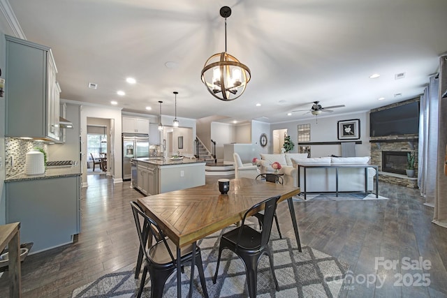 5424 Tilley Manor Dr, Matthews, NC 28105 - dining room with dark wood finished floors, a fireplace, recessed lighting, stairway, and a ceiling fan