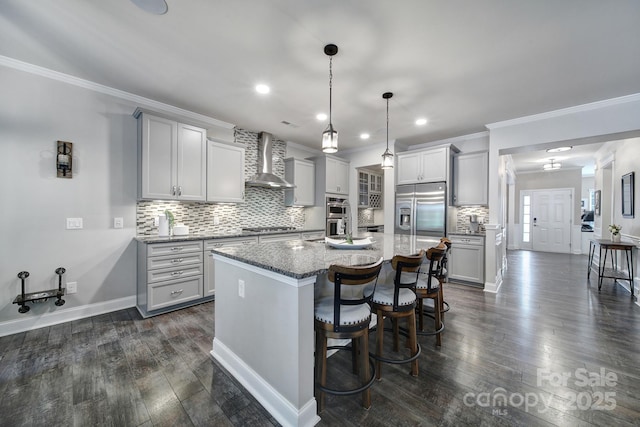 5424 Tilley Manor Dr, Matthews, NC 28105 - kitchen featuring stainless steel appliances, tasteful backsplash, dark stone counters, wall chimney range hood, and dark wood finished floors