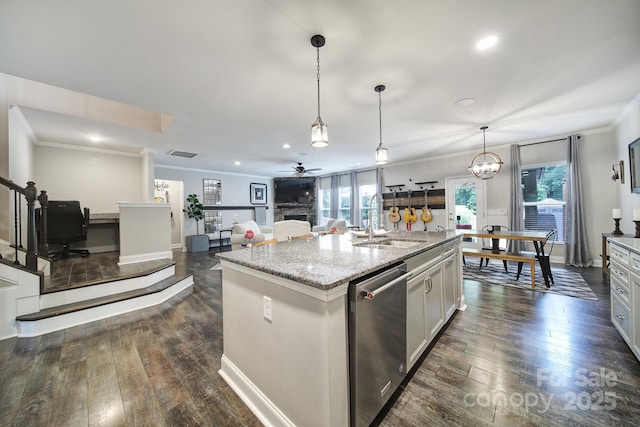 5424 Tilley Manor Dr, Matthews, NC 28105 - kitchen with stainless steel dishwasher, ornamental molding, dark wood-type flooring, a kitchen island with sink, and light stone counters