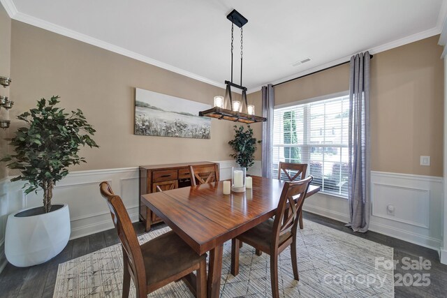 5424 Tilley Manor Dr, Matthews, NC 28105 - dining space featuring wood finished floors, a wainscoted wall, crown molding, a chandelier, and a decorative wall
