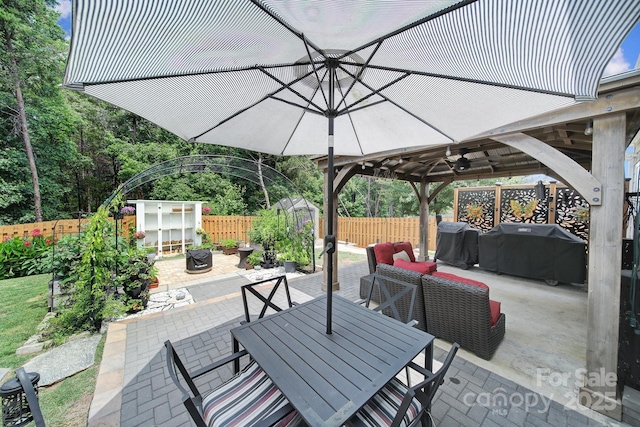 5424 Tilley Manor Dr, Matthews, NC 28105 - fenced backyard with area for grilling, a patio, a gazebo, a ceiling fan, and outdoor dining space