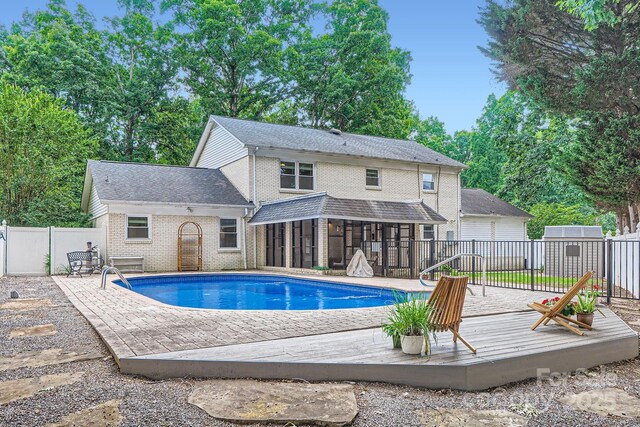 1175 18th Ave NE, Hickory, NC 28601 - view of swimming pool featuring a wooden deck, a fenced backyard, and a sunroom
