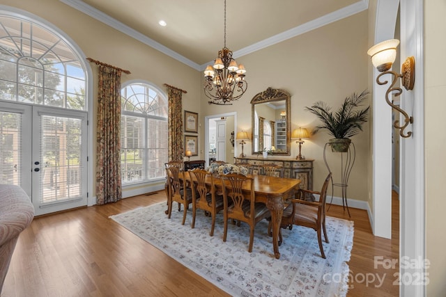 1629 Southpoint Ln, New London, NC 28127 - dining area featuring a chandelier, french doors, ornamental molding, wood finished floors, and a towering ceiling