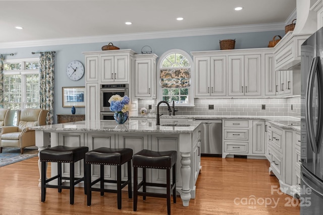 1629 Southpoint Ln, New London, NC 28127 - kitchen with stainless steel appliances, light wood-style flooring, a breakfast bar area, crown molding, and recessed lighting
