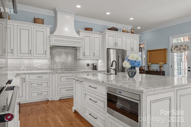 1629 Southpoint Ln, New London, NC 28127 - kitchen with premium range hood, freestanding refrigerator, decorative backsplash, white cabinetry, and ornamental molding