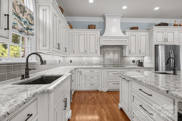 1629 Southpoint Ln, New London, NC 28127 - kitchen featuring a sink, freestanding refrigerator, white cabinetry, custom range hood, and ornamental molding