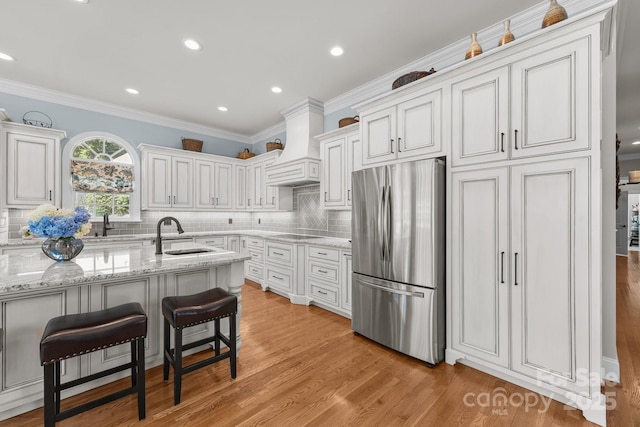 1629 Southpoint Ln, New London, NC 28127 - kitchen with freestanding refrigerator, a sink, custom exhaust hood, crown molding, and tasteful backsplash