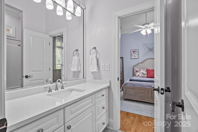 1629 Southpoint Ln, New London, NC 28127 - bathroom with vanity, connected bathroom, a ceiling fan, wood finished floors, and ornamental molding