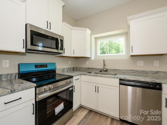 102 Mobley St, Clover, SC 29710 - kitchen with stainless steel appliances, white cabinets, light wood-type flooring, and light stone counters
