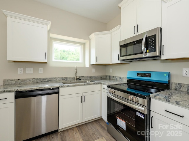 102 Mobley St, Clover, SC 29710 - kitchen with appliances with stainless steel finishes, light wood-style flooring, white cabinetry, and light stone countertops