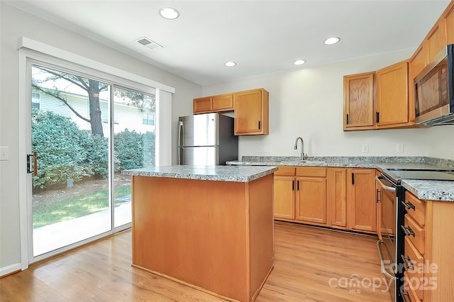 10032 Pergola View Ct, Charlotte, NC 28213 - kitchen with appliances with stainless steel finishes, a sink, a center island, light wood-style floors, and recessed lighting