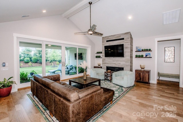 13708 Huntson Park Ln, Huntersville, NC 28078 - living area with a ceiling fan, a tiled fireplace, beam ceiling, light wood-type flooring, and high vaulted ceiling