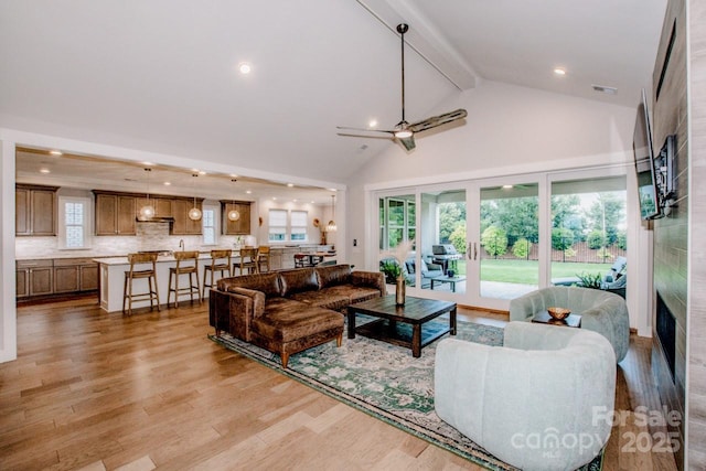 13708 Huntson Park Ln, Huntersville, NC 28078 - living area featuring a large fireplace, beam ceiling, light wood finished floors, high vaulted ceiling, and a ceiling fan