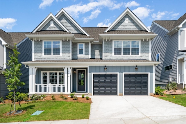 18019 Wilbanks Dr, Charlotte, NC 28278 - view of front of house featuring board and batten siding, a porch, concrete driveway, and a front lawn