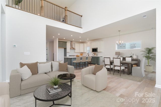 18019 Wilbanks Dr, Charlotte, NC 28278 - living area with a chandelier, light wood-style flooring, and a towering ceiling
