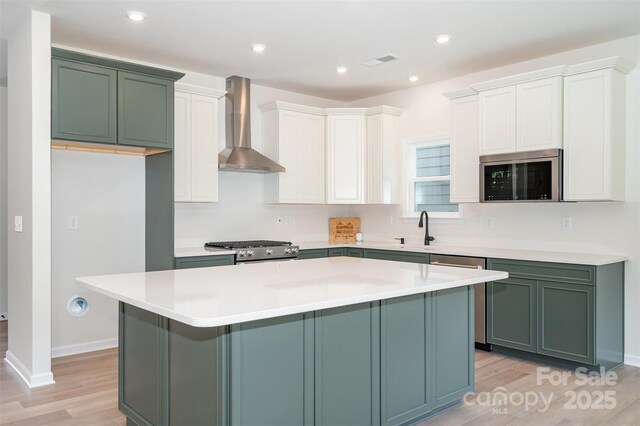 18019 Wilbanks Dr, Charlotte, NC 28278 - kitchen with wall chimney range hood, stainless steel appliances, light wood-style floors, a center island, and light countertops