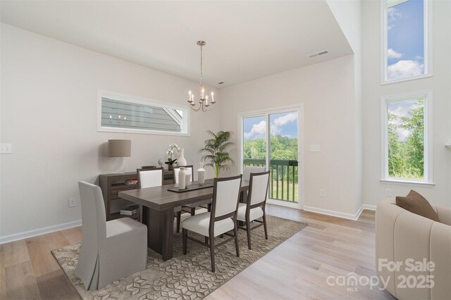 18019 Wilbanks Dr, Charlotte, NC 28278 - dining area with light wood-style floors, a chandelier, baseboards, and arched walkways