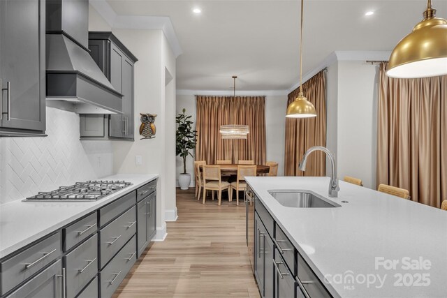 513 Meadow Ridge Dr, Belmont, NC 28012 - kitchen with a sink, wall chimney exhaust hood, stainless steel gas cooktop, decorative backsplash, and light countertops