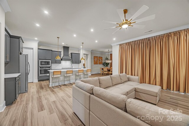 513 Meadow Ridge Dr, Belmont, NC 28012 - living room with crown molding, light wood finished floors, ceiling fan, recessed lighting, and baseboards