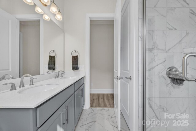 513 Meadow Ridge Dr, Belmont, NC 28012 - bathroom featuring double vanity, marble look tile flooring, a shower stall, and baseboards