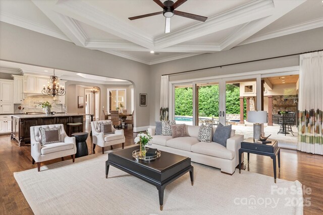 1501 Alydar Ct, Waxhaw, NC 28173 - living area featuring arched walkways, a ceiling fan, a chandelier, ornamental molding, and beamed ceiling