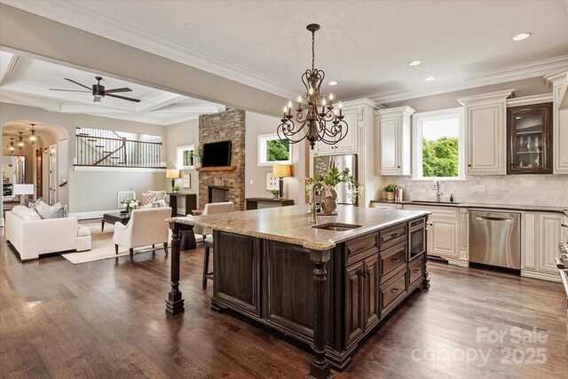 1501 Alydar Ct, Waxhaw, NC 28173 - kitchen with appliances with stainless steel finishes, a sink, a fireplace, open floor plan, and crown molding