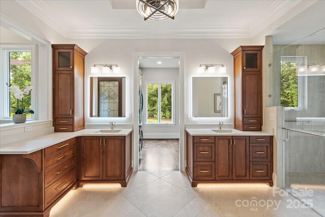 1501 Alydar Ct, Waxhaw, NC 28173 - bathroom featuring two vanities, a stall shower, tile patterned floors, and crown molding